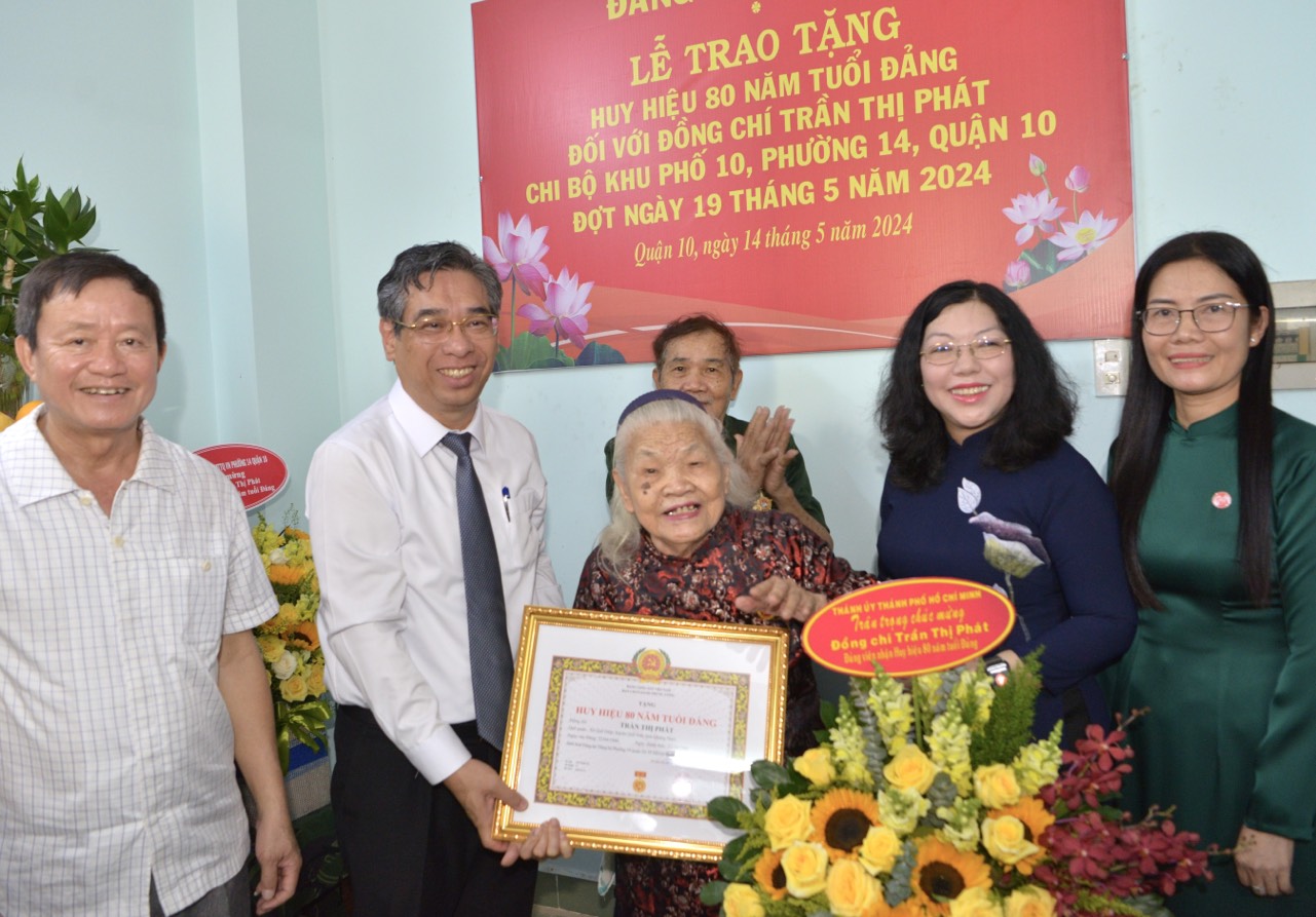 Phó Bí thư Thành ủy TP. Hồ Chí Minh Nguyễn Phước Lộc cùng lãnh đạo quận 10 chúc mừng đến đồng chí Trần Thị Phát và gia đình (Ảnh: Cao Thăng).